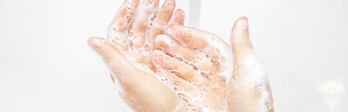 Person washing their hands with soapy water